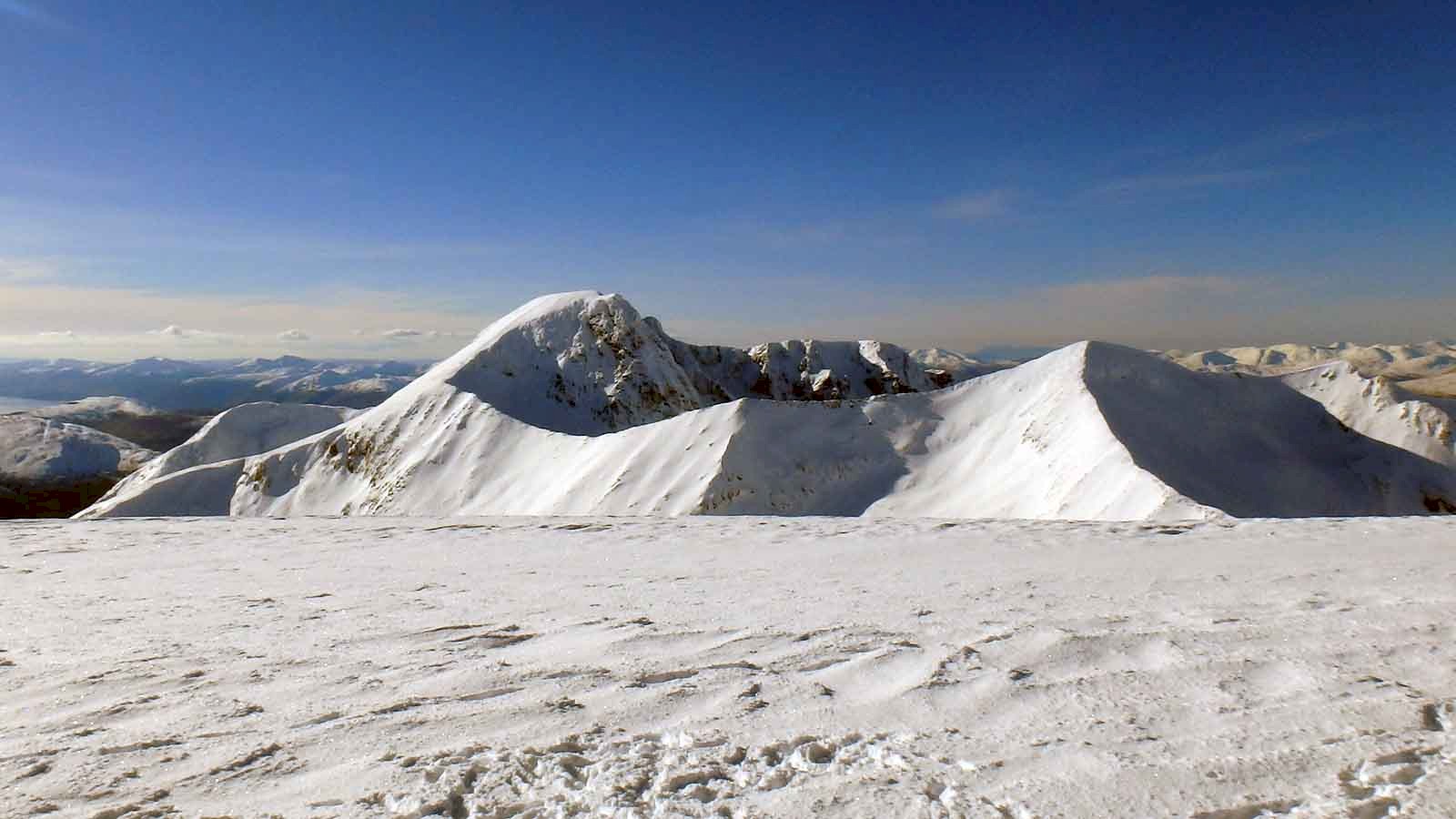 View of Ben Nevis behind the Carn Mor Dearg arete from the summit of Aonach Beag in stunning winter conditions.
